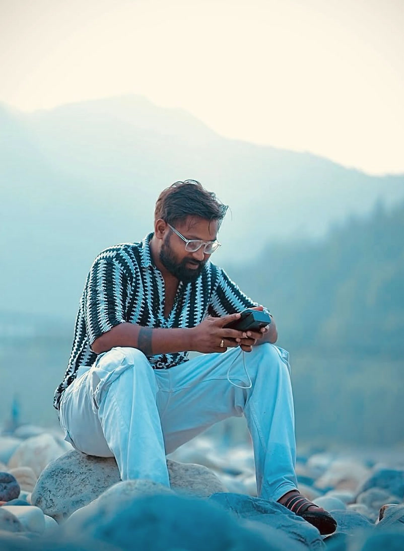 Devansh Kushwah reviewing cinema drone coordinates on river boulders