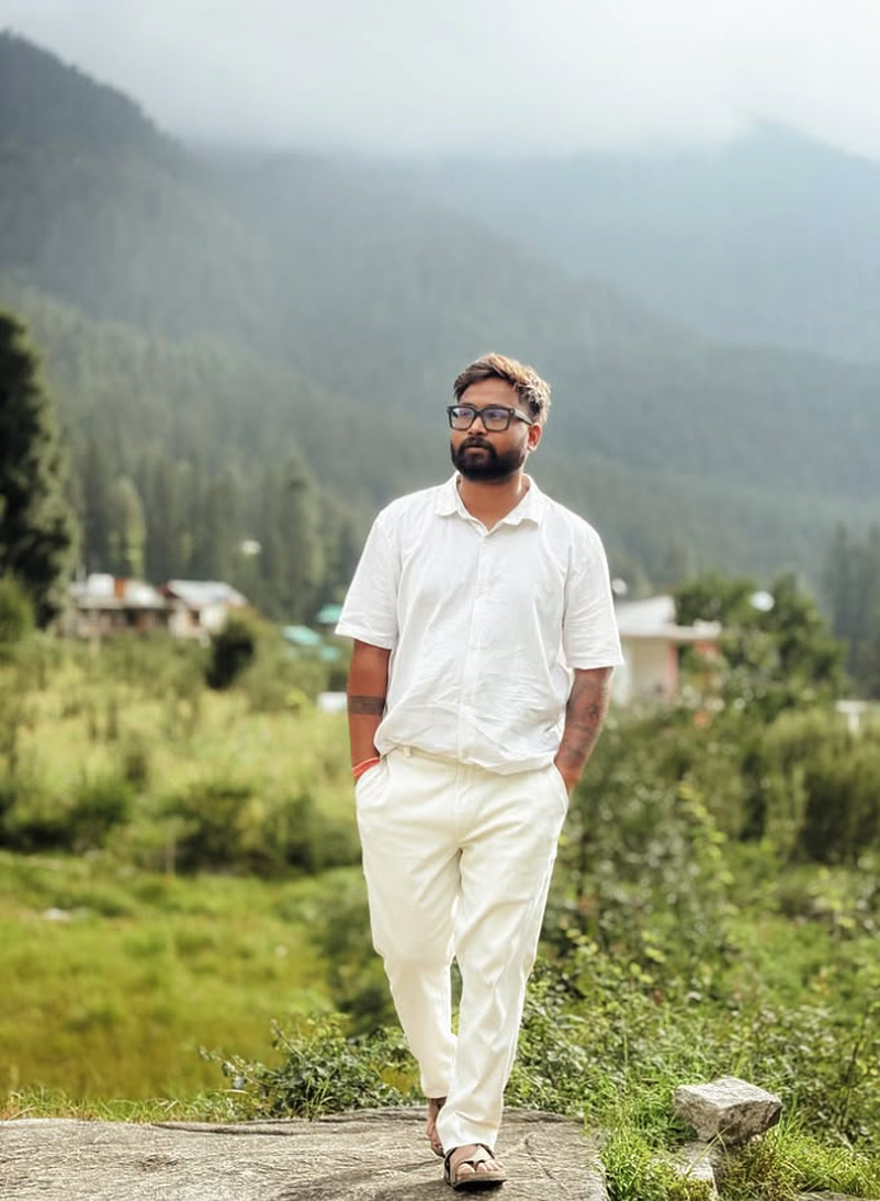 Devansh Singh walking through misty Himalayan pine valleys in all-white editorial outfit — Kamal Productions Devansh Singh